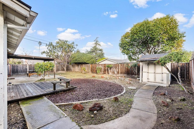 view of yard featuring a wooden deck and a storage unit