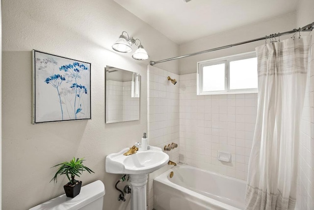 bathroom featuring shower / bath combination with curtain and toilet