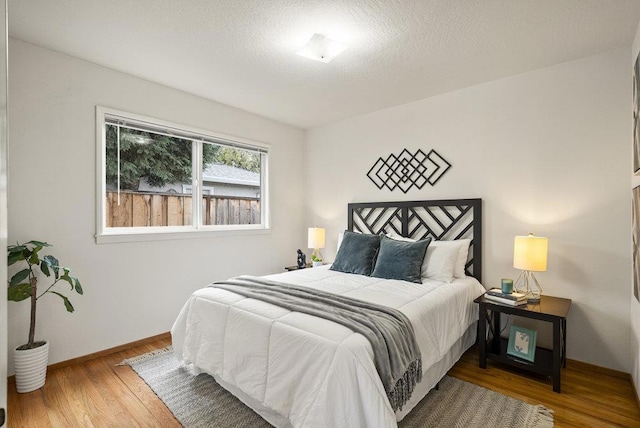 bedroom with wood-type flooring and a textured ceiling