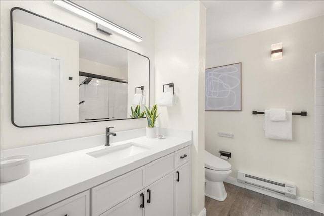 bathroom featuring a baseboard heating unit, hardwood / wood-style floors, vanity, toilet, and walk in shower