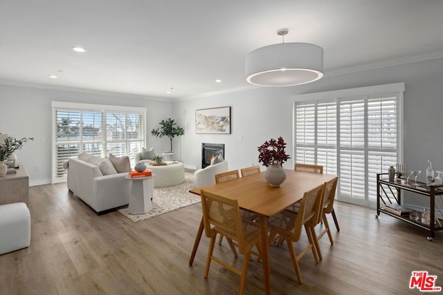 dining room featuring ornamental molding and light wood-type flooring