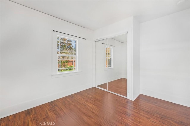 unfurnished bedroom with hardwood / wood-style flooring and a closet