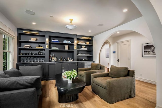 living room with wet bar and light hardwood / wood-style floors