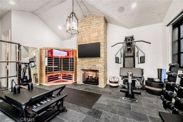 exercise room featuring lofted ceiling, a chandelier, wooden ceiling, and a fireplace