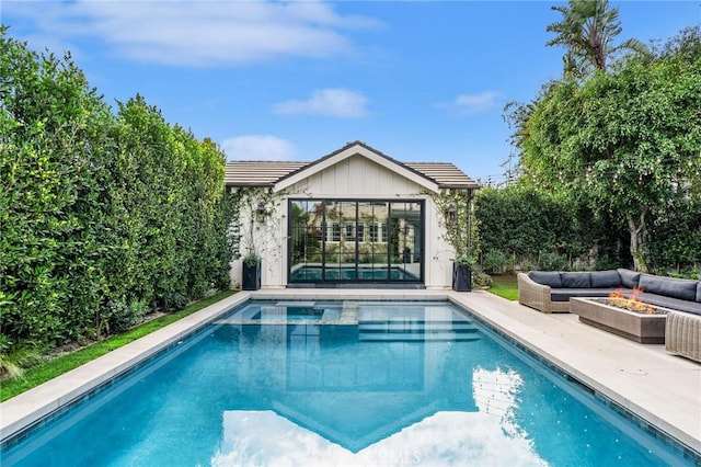 view of pool featuring an outbuilding, a patio area, and an outdoor fire pit