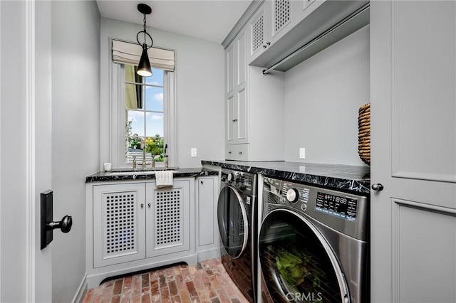 clothes washing area with cabinets and independent washer and dryer