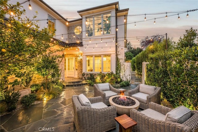 exterior space featuring a balcony and an outdoor living space with a fire pit