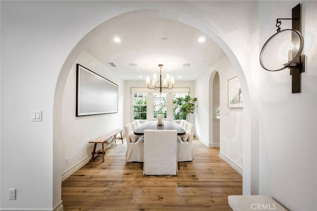 dining space featuring a notable chandelier and light hardwood / wood-style floors