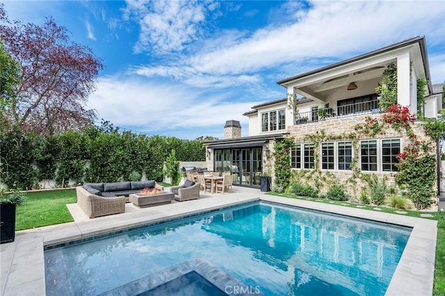 back of house with outdoor lounge area, a patio, and a balcony