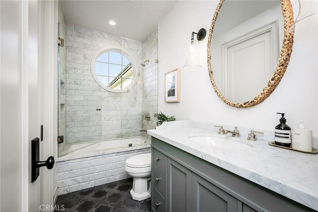 full bathroom with tiled shower / bath combo, vanity, and toilet