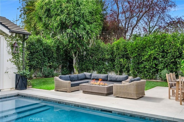 view of pool with a patio and an outdoor living space with a fire pit