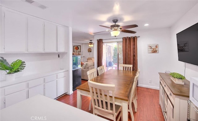 dining space with ceiling fan and light hardwood / wood-style floors