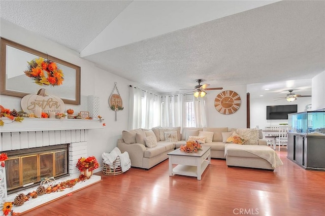 living room featuring a fireplace, hardwood / wood-style floors, and a textured ceiling