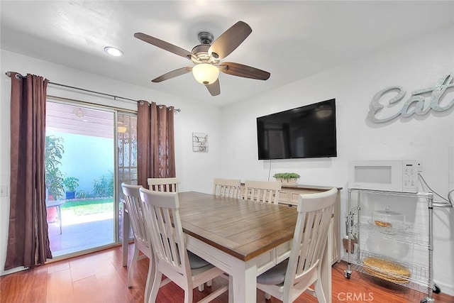 dining space with wood-type flooring and ceiling fan