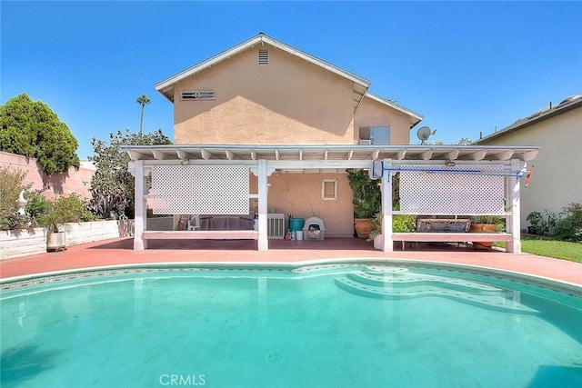 back of property with a fenced in pool and a pergola