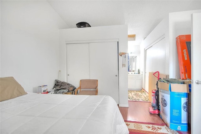 bedroom featuring hardwood / wood-style flooring, a closet, and a textured ceiling