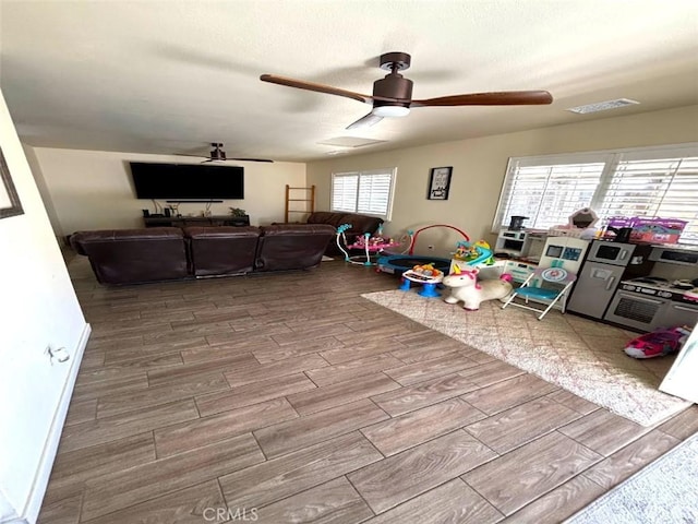 rec room with ceiling fan and a textured ceiling