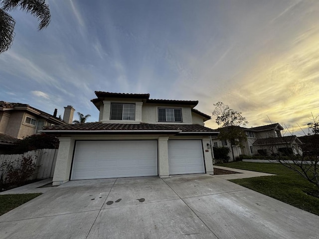 view of front of property featuring a garage and a lawn