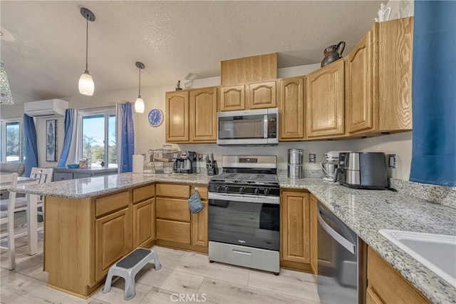 kitchen featuring pendant lighting, appliances with stainless steel finishes, kitchen peninsula, a textured ceiling, and an AC wall unit