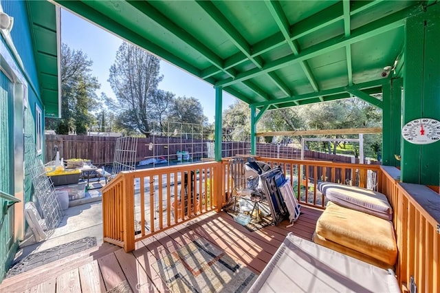 wooden deck with a fenced backyard