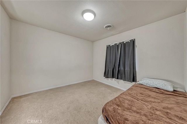 carpeted bedroom with visible vents and baseboards