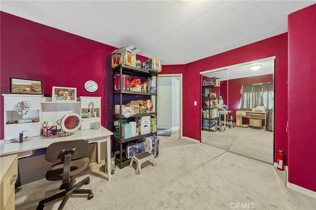 carpeted home office with a textured ceiling