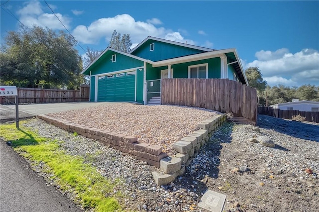 view of front of home featuring a garage, fence, and decorative driveway