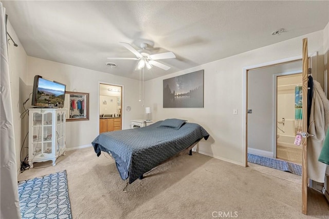 bedroom featuring ensuite bath, baseboards, a ceiling fan, and light colored carpet