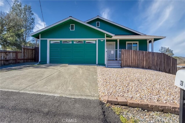 view of front of house featuring driveway, an attached garage, fence, and a porch