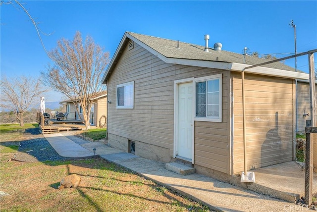 view of property exterior with a wooden deck and a garage