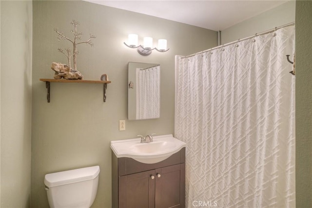 bathroom featuring vanity, toilet, and curtained shower