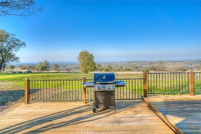 deck with area for grilling, a lawn, and a rural view