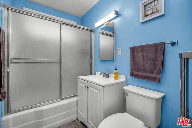 full bathroom featuring vanity, toilet, and combined bath / shower with glass door