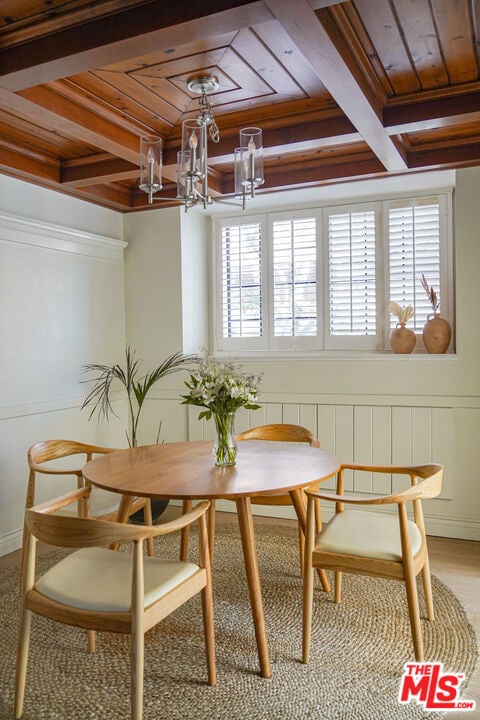 dining area featuring coffered ceiling, a chandelier, beam ceiling, and breakfast area