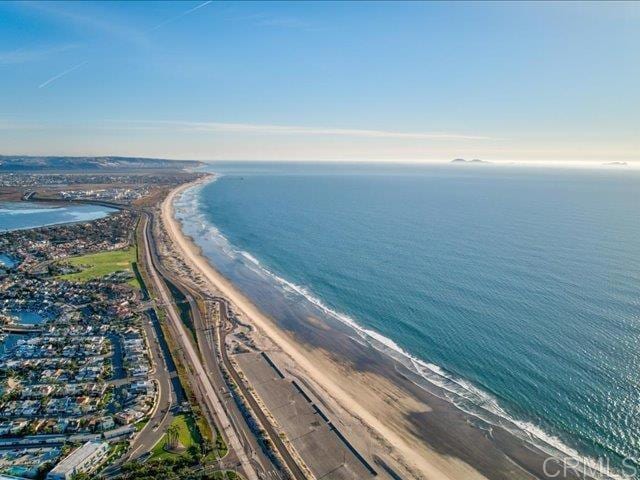 drone / aerial view with a water view and a beach view