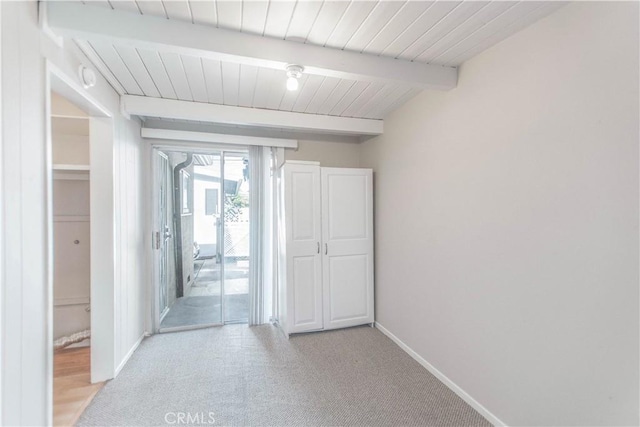 corridor featuring light carpet and beam ceiling