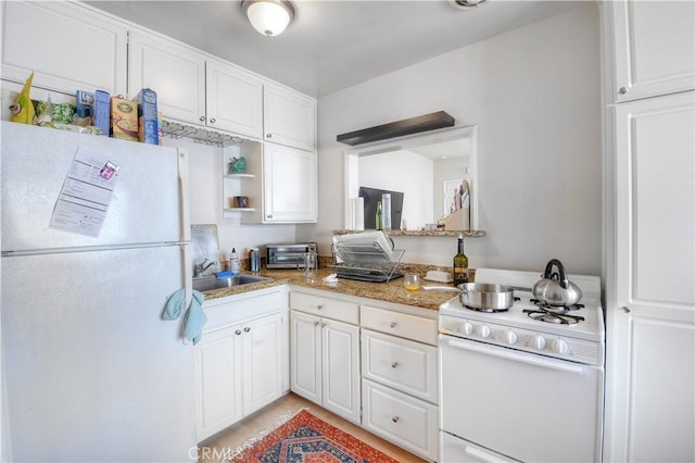 kitchen with white cabinetry, sink, white appliances, and light stone counters