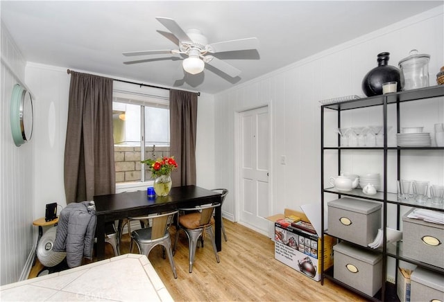 dining area with crown molding, ceiling fan, and light hardwood / wood-style flooring