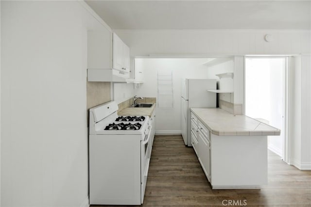 kitchen with sink, tile countertops, dark hardwood / wood-style flooring, white appliances, and white cabinets