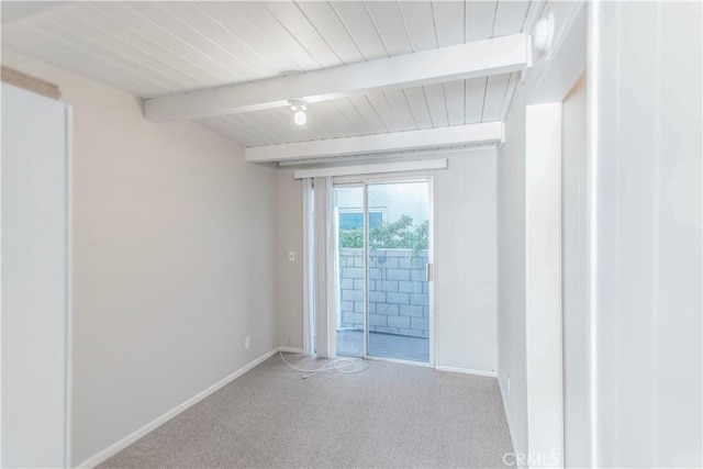 spare room with beamed ceiling and carpet floors