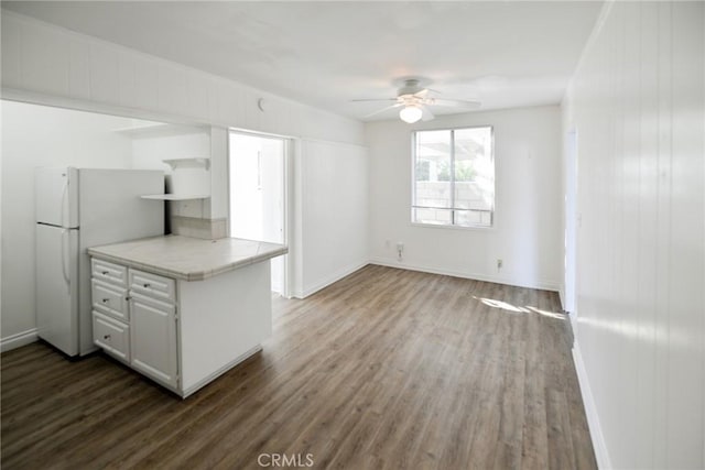 kitchen with white cabinetry, dark wood-type flooring, ceiling fan, and white fridge