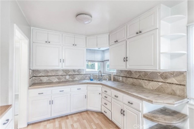 kitchen with tasteful backsplash, sink, tile countertops, and white cabinets