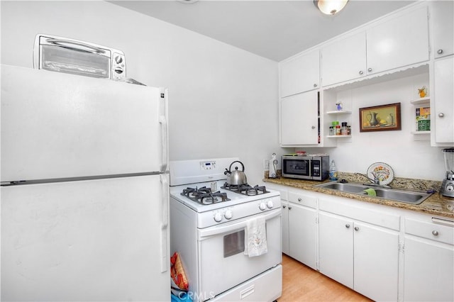 kitchen with white cabinetry, sink, white appliances, and light hardwood / wood-style flooring