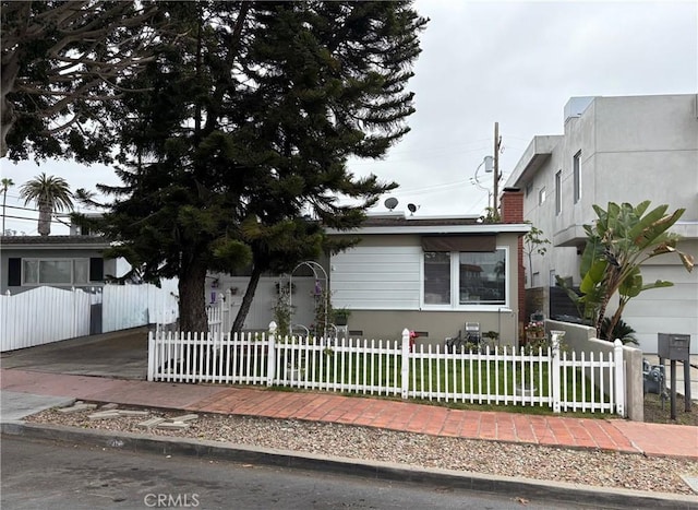 view of front of house featuring a fenced front yard, a front yard, and a chimney