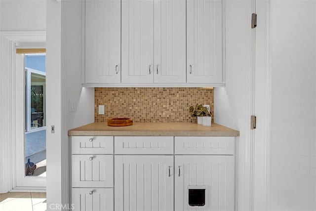 interior space with white cabinetry and tasteful backsplash