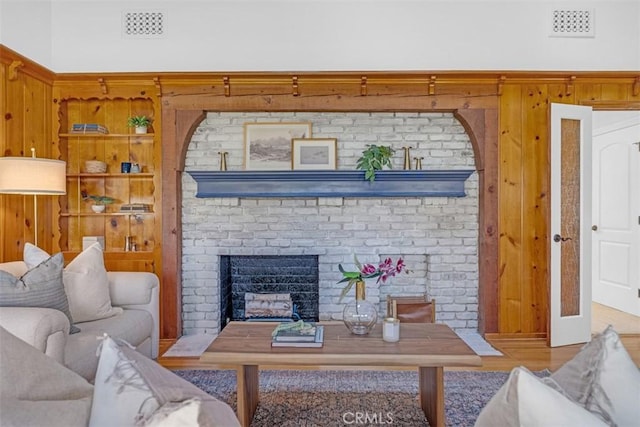 living room featuring hardwood / wood-style flooring and a brick fireplace