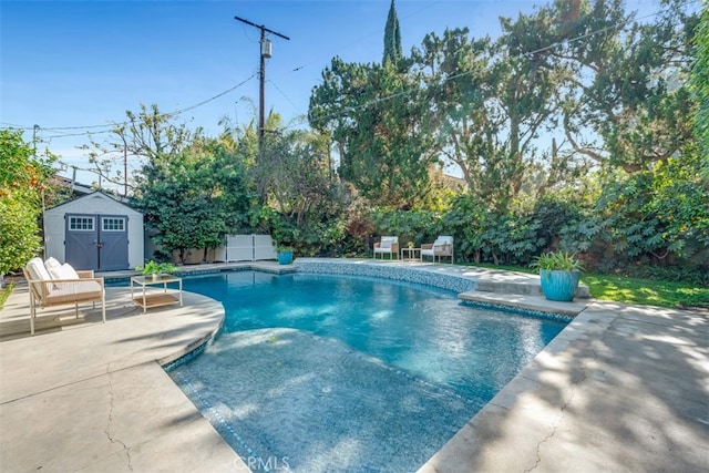 view of pool with a patio and a storage shed