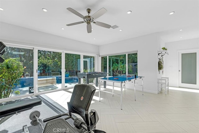 sunroom / solarium featuring ceiling fan