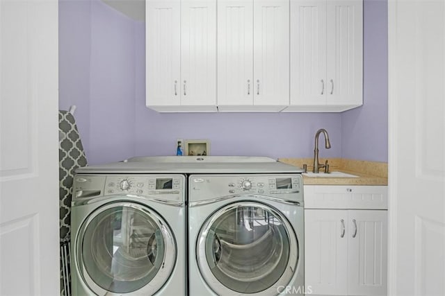 laundry area with cabinets, washer and dryer, and sink