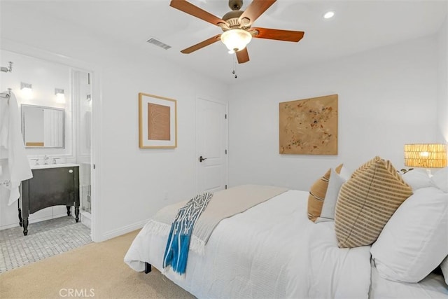 bedroom with light carpet, connected bathroom, and ceiling fan